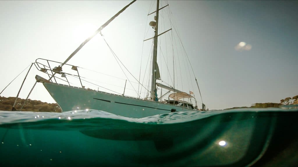 Shot taken from the water looking up at a sailing yacht